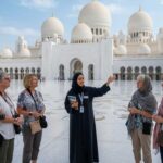 A Female Tour Guide explaining history to tourists at sheikh zayed grand mosque