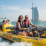 Yellow boat tour dubai couple smiling on boat splashing sea waves