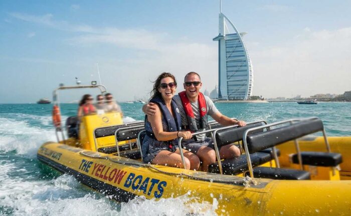 Yellow boat tour dubai couple smiling on boat splashing sea waves