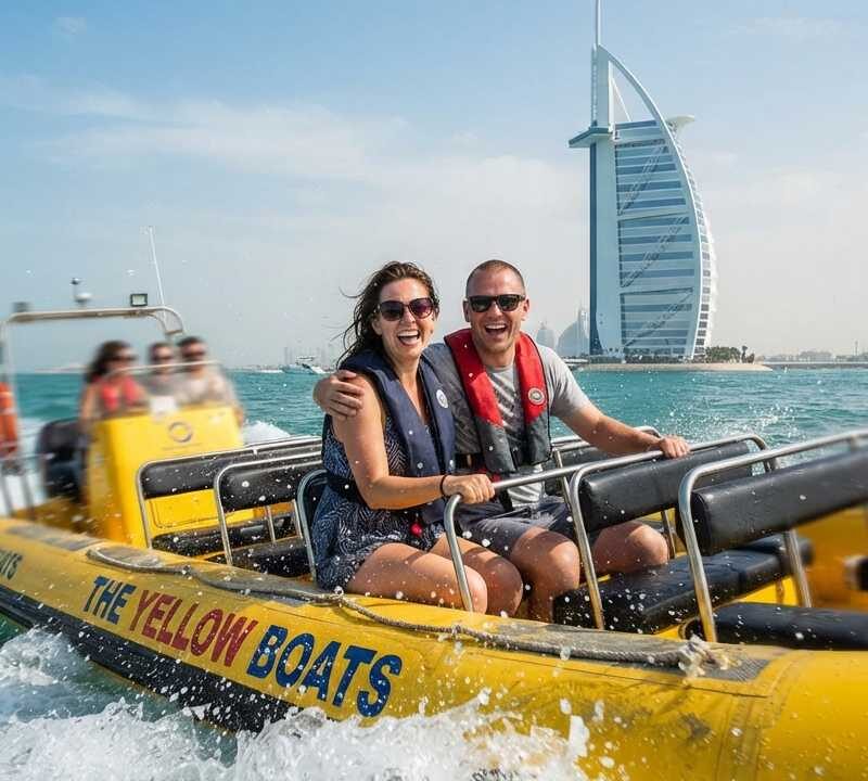Yellow boat tour dubai couple smiling on boat splashing sea waves